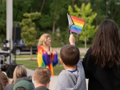 Kid holding up a pride flag at the Meridian Pride event