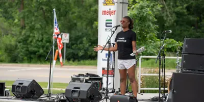 Amber Clark standing on stage and talking into a microphone