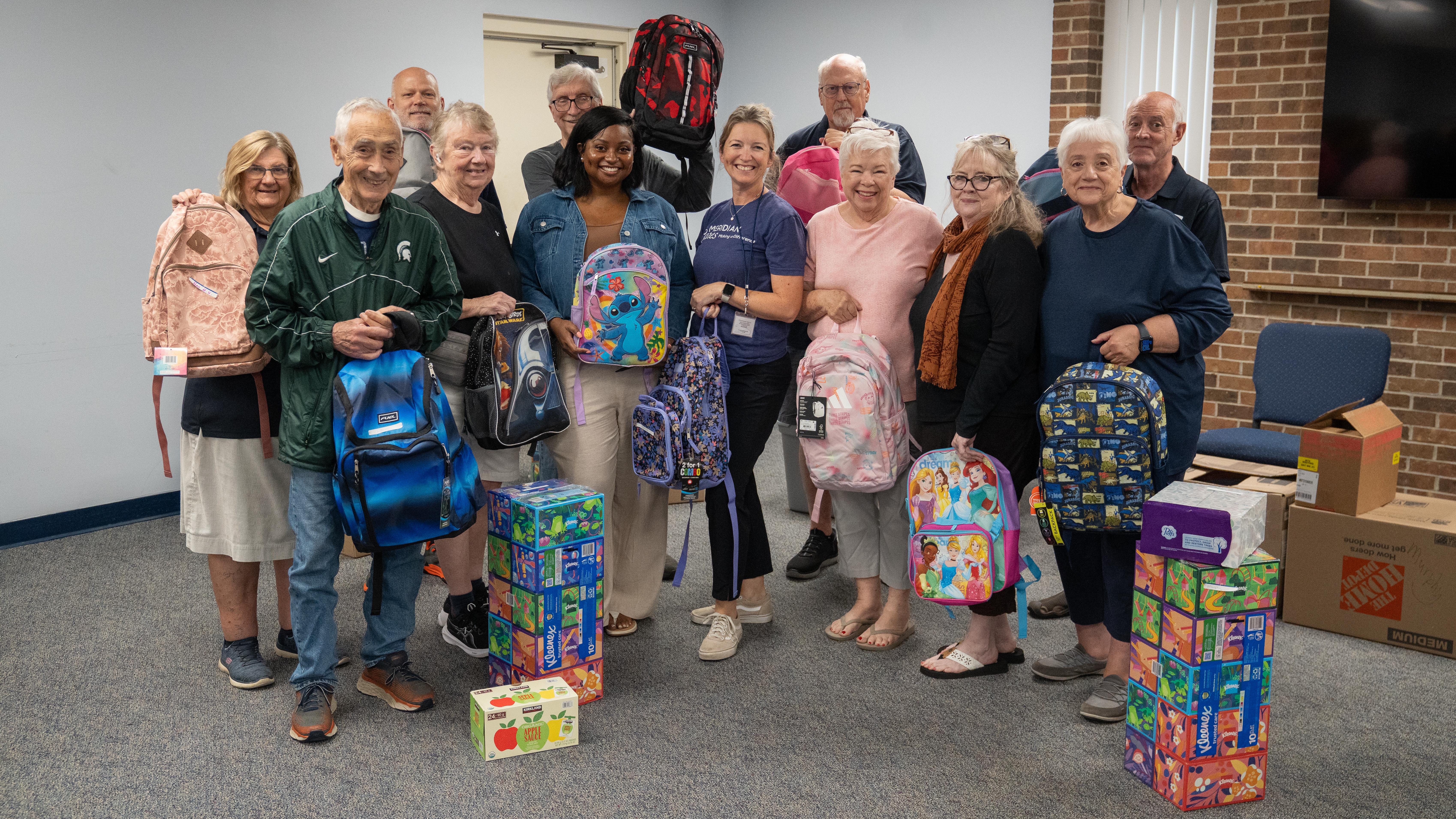 Volunteers packing backpacks of school supplies for area children